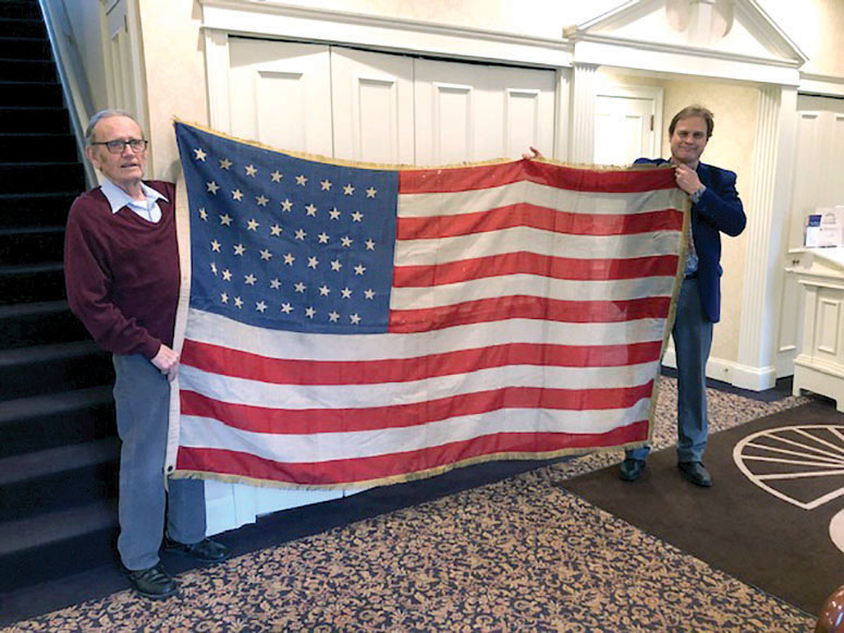 JOe Sr. and Joe E Pray hold the 48 star American Flag that draped the caskets of Charlotte's Civial War Veterans